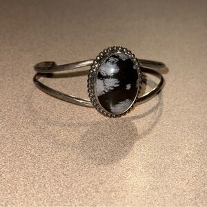 Navajo sterling silver cuff bracelet with a large oval snowflake obsidian stone